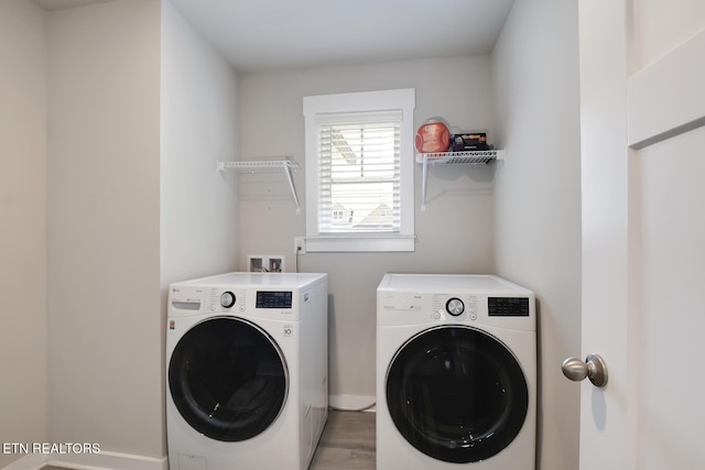 laundry room featuring separate washer and dryer and hardwood / wood-style flooring