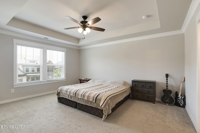 bedroom with ornamental molding, a tray ceiling, ceiling fan, and light colored carpet