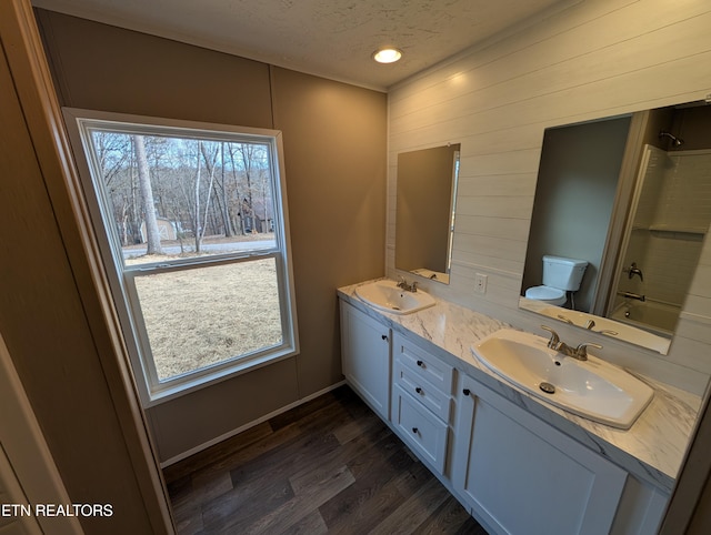 full bathroom featuring hardwood / wood-style floors, a textured ceiling, toilet, shower / tub combination, and vanity