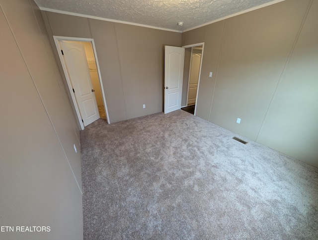 unfurnished bedroom featuring carpet floors, a textured ceiling, and ornamental molding