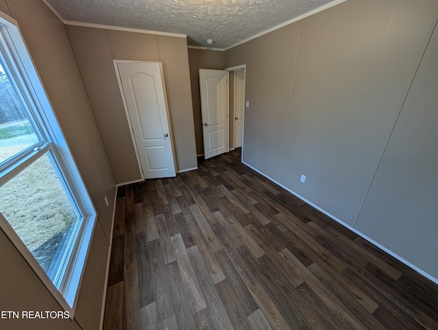 unfurnished bedroom featuring crown molding, dark hardwood / wood-style flooring, and a textured ceiling