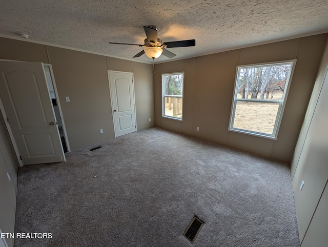 unfurnished bedroom with carpet flooring, ceiling fan, and a textured ceiling