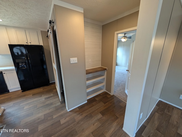 corridor featuring dark hardwood / wood-style floors, a barn door, and a textured ceiling