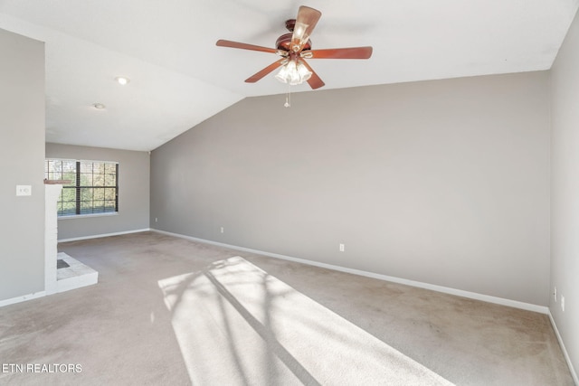 spare room featuring light colored carpet, ceiling fan, and lofted ceiling