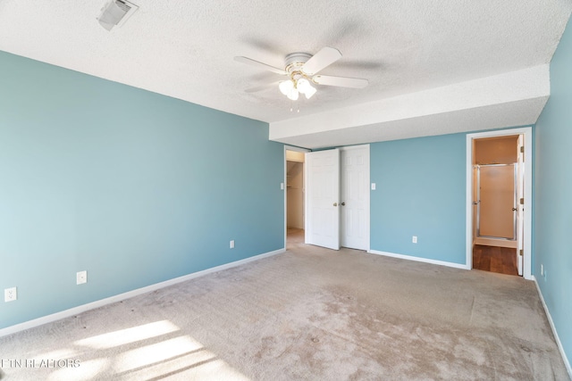 unfurnished bedroom with a textured ceiling, ceiling fan, light carpet, and a closet