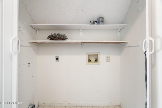 laundry room with hookup for an electric dryer, washer hookup, and a textured ceiling