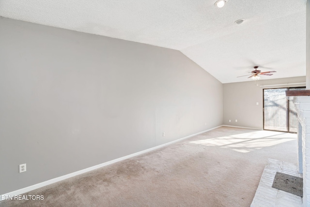 unfurnished room featuring a textured ceiling, ceiling fan, light colored carpet, and lofted ceiling