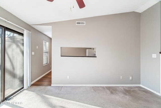 carpeted spare room with ceiling fan and lofted ceiling