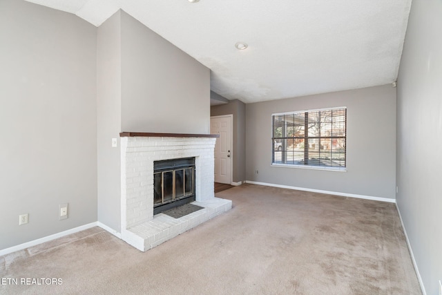 unfurnished living room with light carpet, a brick fireplace, and lofted ceiling