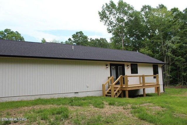 rear view of property with a lawn and a wooden deck