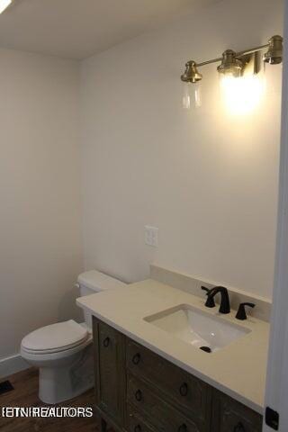 bathroom with vanity, toilet, and wood-type flooring