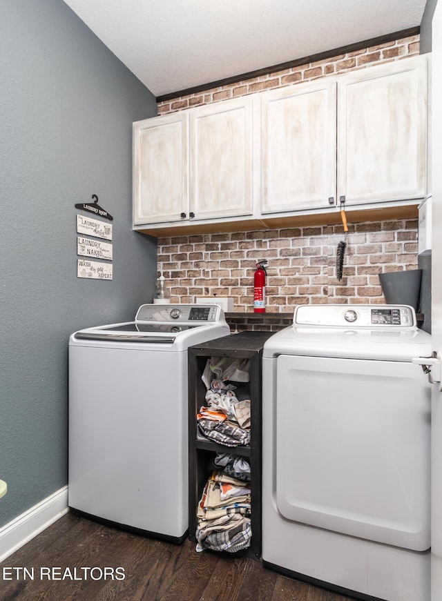 laundry room featuring cabinets, dark hardwood / wood-style flooring, and washing machine and clothes dryer