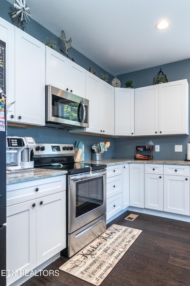 kitchen featuring dark hardwood / wood-style flooring, stainless steel appliances, and white cabinetry