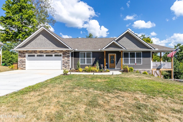 view of front of property with a front yard, covered porch, and a garage