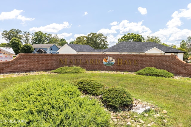 community sign featuring a lawn