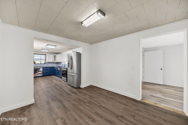 interior space with dark wood-style floors, a sink, and baseboards