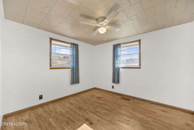 spare room with visible vents, plenty of natural light, and wood finished floors