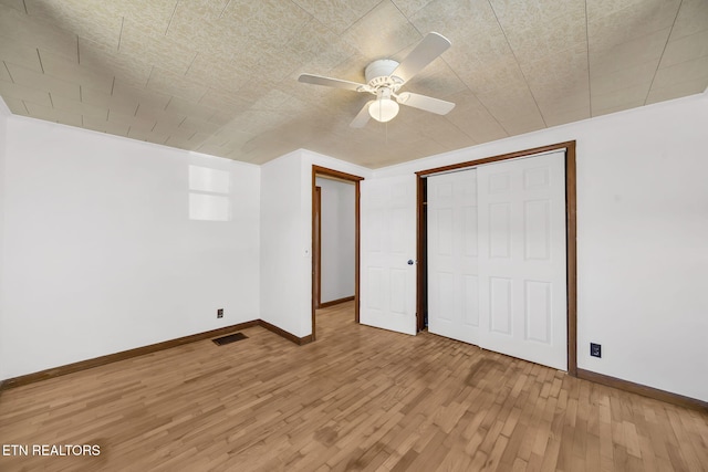 unfurnished bedroom with light wood-style flooring, a closet, visible vents, and baseboards