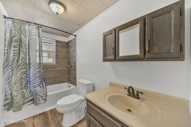 full bath featuring toilet, wood finished floors, vanity, ornamental molding, and shower / bath combo