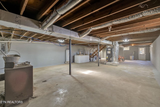 basement featuring water heater, washer and clothes dryer, and heating unit