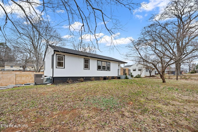 view of side of property with central AC unit and a lawn