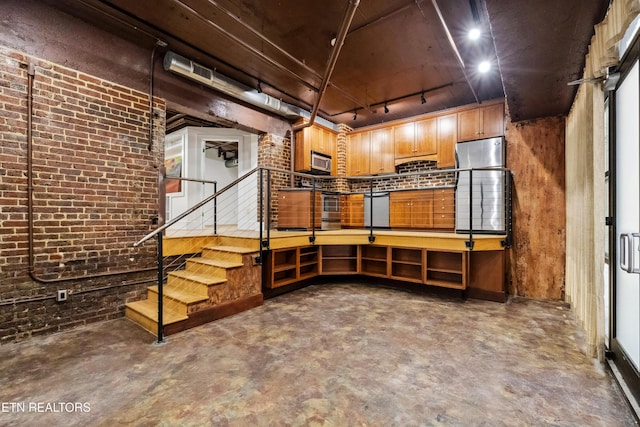 basement with brick wall and track lighting