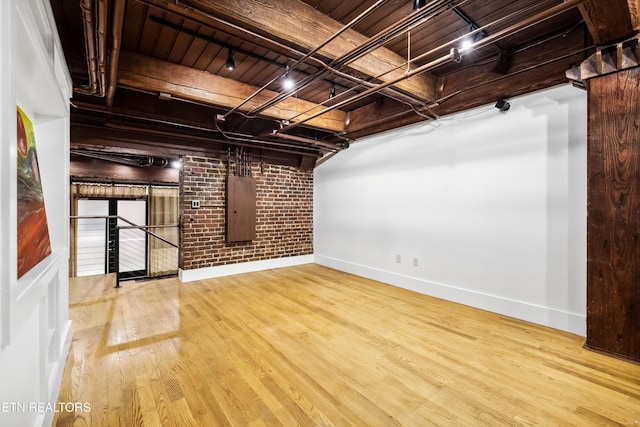 interior space with electric panel, light hardwood / wood-style flooring, wood ceiling, and brick wall