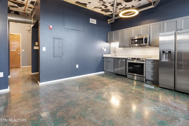 kitchen featuring gray cabinetry, backsplash, sink, a towering ceiling, and stainless steel appliances