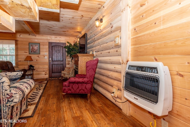 sitting room featuring wooden ceiling, rustic walls, beamed ceiling, wood-type flooring, and heating unit