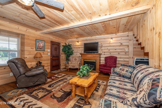 living room with an AC wall unit, hardwood / wood-style flooring, ceiling fan, log walls, and beam ceiling