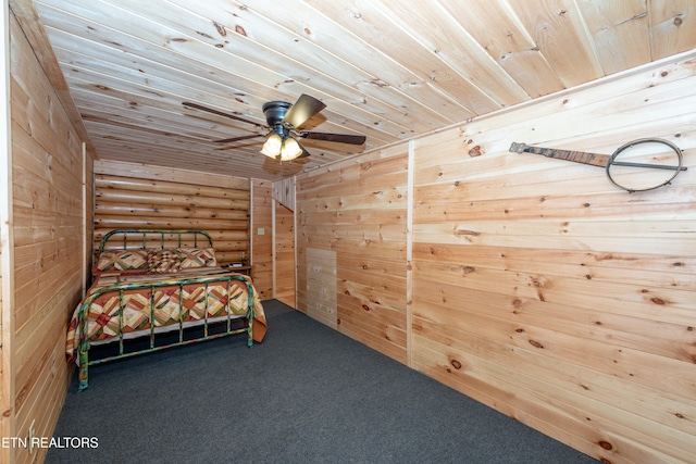 unfurnished bedroom with wood walls, wooden ceiling, carpet flooring, ceiling fan, and rustic walls