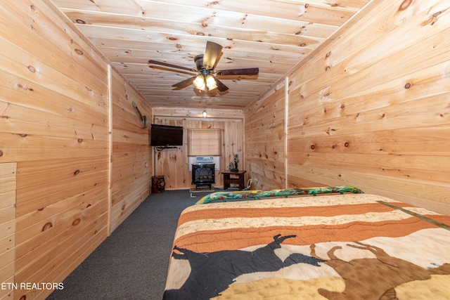 carpeted bedroom with wooden walls and wooden ceiling