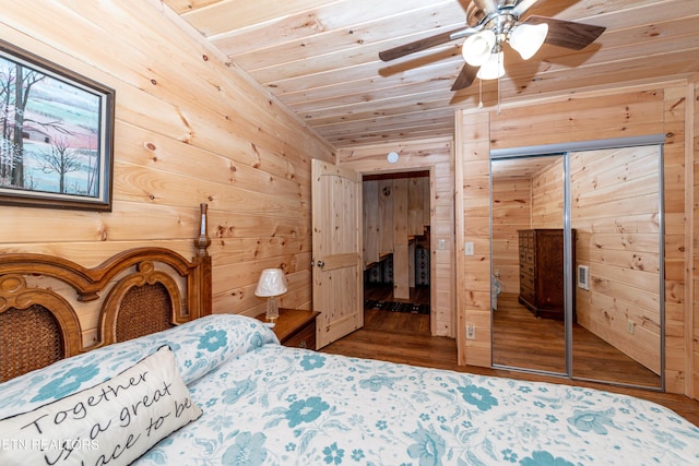 bedroom with ceiling fan, a closet, wooden ceiling, and wooden walls