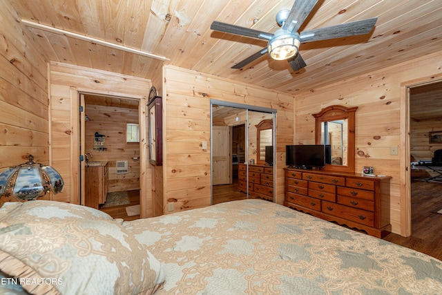 bedroom featuring wooden walls, hardwood / wood-style flooring, ceiling fan, wood ceiling, and a closet