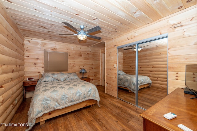 bedroom featuring rustic walls, ceiling fan, wooden ceiling, hardwood / wood-style floors, and a closet