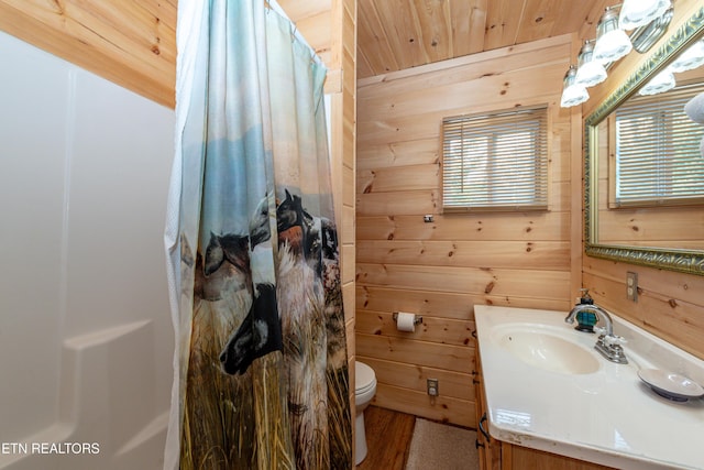 bathroom with walk in shower, vanity, wood-type flooring, toilet, and wood walls