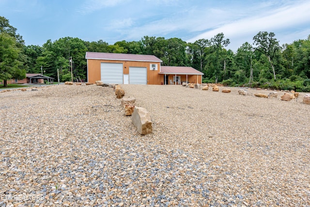 view of front facade featuring a garage and an outbuilding