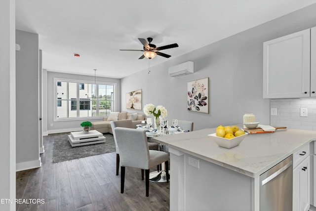 kitchen with light stone countertops, tasteful backsplash, a wall mounted AC, dishwasher, and white cabinets