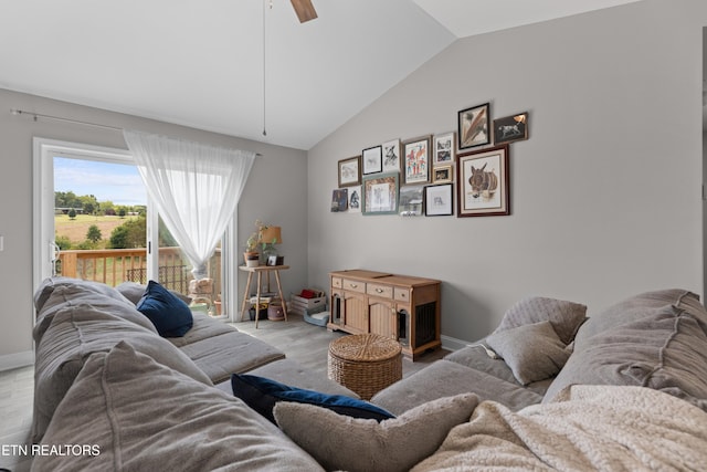 living room featuring ceiling fan, light wood-type flooring, and vaulted ceiling