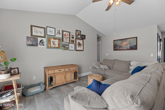 living room with ceiling fan, light hardwood / wood-style floors, and vaulted ceiling