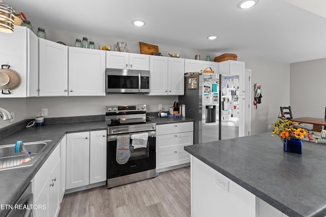 kitchen featuring white cabinetry, sink, stainless steel appliances, and light hardwood / wood-style flooring