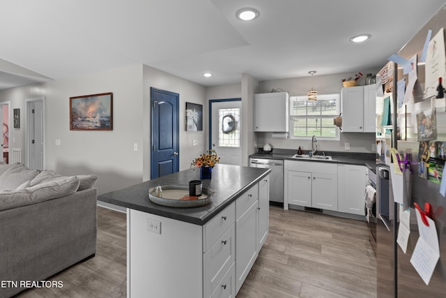 kitchen featuring a center island, sink, stainless steel dishwasher, light hardwood / wood-style floors, and white cabinets