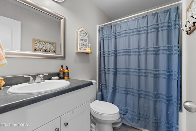 bathroom with vanity, toilet, and curtained shower