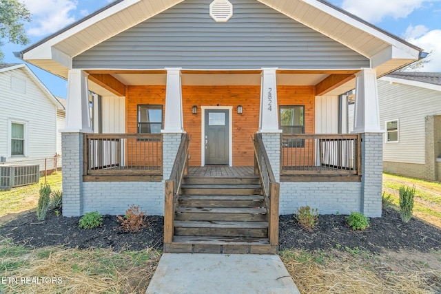 bungalow-style home with a porch and cooling unit