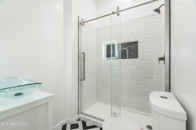 bathroom with vanity, a shower with shower door, and toilet