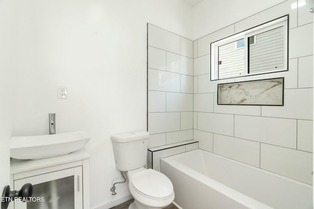 full bathroom featuring toilet, vanity, and tiled shower / bath