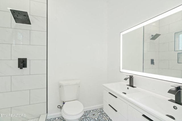 bathroom with tile patterned floors, a tile shower, vanity, and toilet