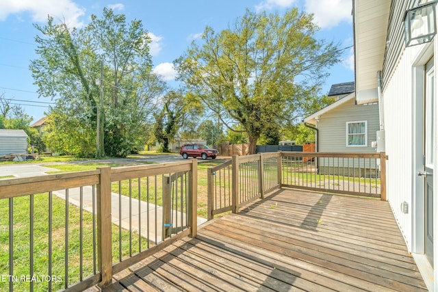 wooden terrace featuring a yard