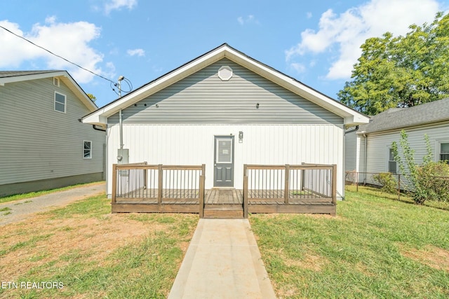 rear view of property with a yard and a wooden deck