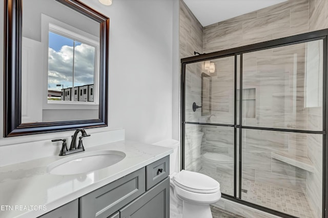 bathroom with toilet, vanity, and walk in shower